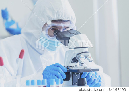 Male Scientist look into Microscope research in science laboratory. Asian scientist looking equipment laboratory chemistry labs. Covid-19 coronavirus biochemistry research experiment vaccine concept 84167493