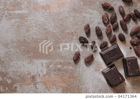 chocolate pieces with raw cocoa beans rustic background. High quality beautiful photo concept chocolate pieces with raw cocoa beans rustic background. High quality beautiful photo concept 84171364