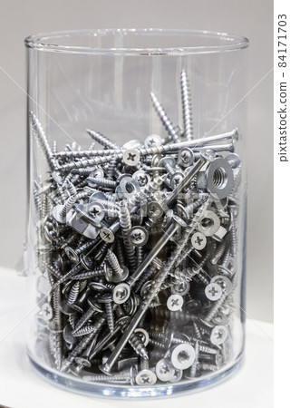 jar with screws on a light background jar with screws on a light background 84171703