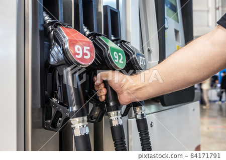 hand holds the filling gun at a gasoline gas station 84171791