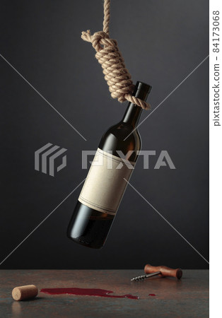 Bottle of wine hangs in a loop. 84173068