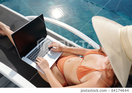 Woman in Bikini Coding on Laptop 84174644