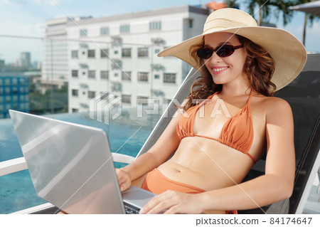 Woman in Bikini Answering E-mails 84174647