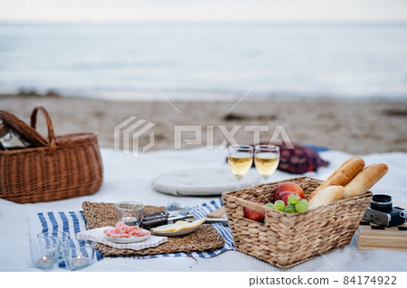 Beach picnic with schripms, beer, fruit and candles Beach picnic with schripms, beer, fruit and candles 84174922