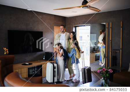 Happy young family with two children enetring room at luxury hotel, summer holiday. 84175033