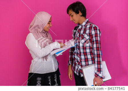 Arabic teenagers group, students team walking forward in future and back to school concept pink background. Selective focus Arabic teenagers group, students team walking forward in future and back to school concept pink background. Selective focus 84177541