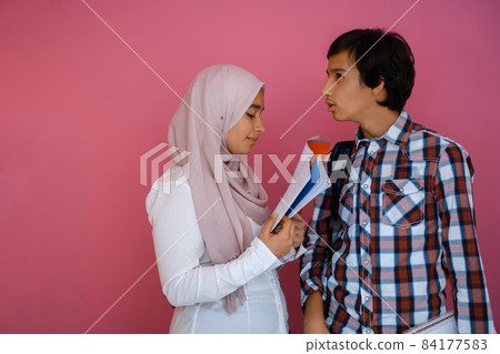 Arabic teenagers group, students team walking forward in future and back to school concept pink background. Selective focus  84177583