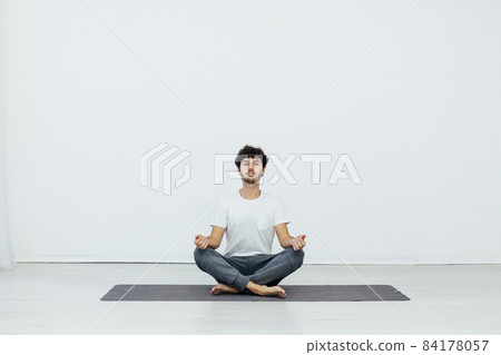 a man doing gymnastics yoga asana in a room 84178057