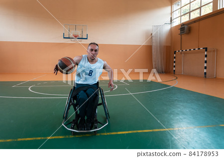 a photo of a war veteran playing basketball in a modern sports arena. The concept of sport for people with disabilities a photo of a war veteran playing basketball in a modern sports arena. The concept of sport for people with disabilities 84178953