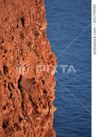Red cliff at the costline in the evening sun Red cliff at the costline in the evening sun 84179099