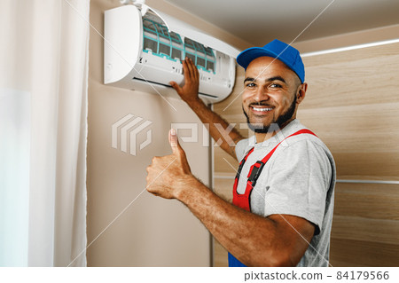 Professional repairman installing air conditioner in a room Professional repairman installing air conditioner in a room 84179566
