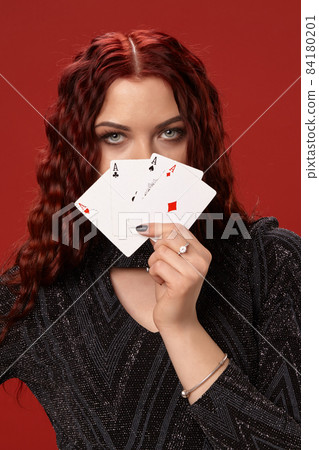 Beautiful redheaded woman is holding some playing cards. Casino Beautiful redheaded woman is holding some playing cards. Casino 84180201