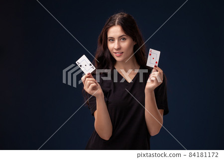 Curly hair brunette is posing with playing cards in her hands. Poker concept on a black background. Casino. Curly hair brunette is posing with playing cards in her hands. Poker concept on a black background. Casino. 84181172