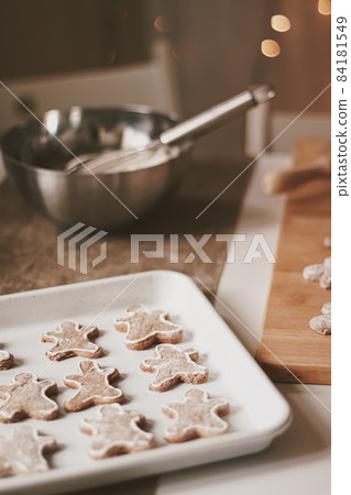 Christmas baking and cooking recipe concept. Food ingredients and preparation process of traditional homemade gingerbread men biscuits in the kitchen at home during winter holidays Christmas baking and cooking recipe concept. Food ingredients and preparation process of traditional homemade gingerbread men biscuits in the kitchen at home during winter holidays 84181549