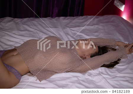 Attractive woman in underwear lying on bed Attractive woman in underwear lying on bed 84182189