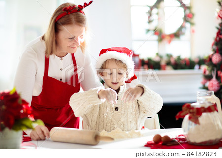 Family baking Christmas cookies. Kids Xmas fun. 84182823