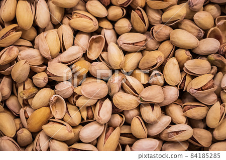 Background of fried pistachios. Nuts for a vegetarian diet. 84185285