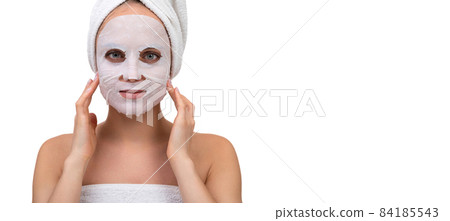 a woman after a shower with a white cosmetic mask on her face massages the skin around the a woman after a shower with a white cosmetic mask on her face massages the skin around the 84185543
