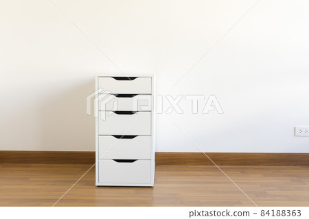 wooden file cabinet on the wooden floor in the white room 84188363