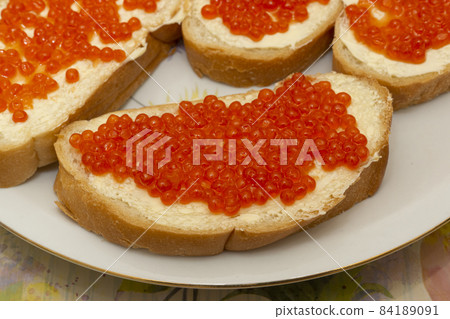 Traditional Russian snack white buns with butter and red fish caviar 84189091