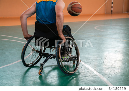 Close up photo of wheelchairs and handicapped war veterans playing basketball on the court Close up photo of wheelchairs and handicapped war veterans playing basketball on the court 84189239
