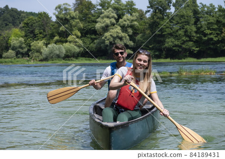 friends are canoeing in a wild river friends are canoeing in a wild river 84189431