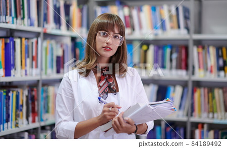 the student uses a notebook and a school library the student uses a notebook and a school library 84189492