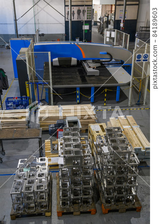 The first phase of metal and aluminum processing. Processed products from CNC machines stacked on a pallet in a large modern factory The first phase of metal and aluminum processing. Processed products from CNC machines stacked on a pallet in a large modern factory 84189603