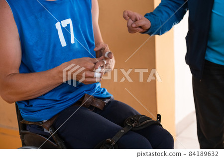 a handicapped basketball player prepares for a match while sitting in a wheelchair.preparations for a professional basketball match. the concept of disability sport 84189632