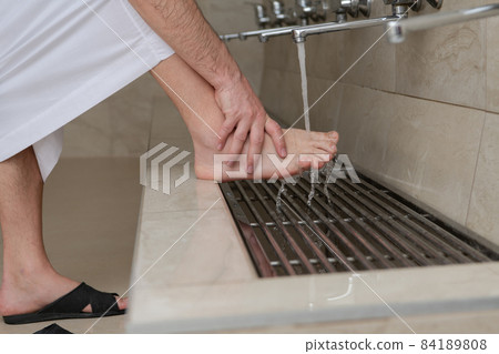 A Muslim takes ablution for prayer. Islamic religious rite A Muslim takes ablution for prayer. Islamic religious rite 84189808