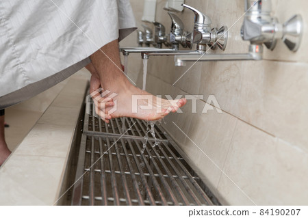 A Muslim takes ablution for prayer. Islamic religious rite 84190207