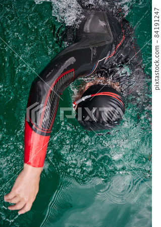 triathlon athlete swimming on lake wearing wetsuit 84191247