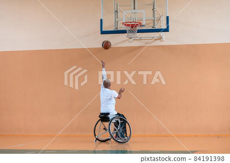 a photo of a war veteran playing basketball in a modern sports arena. The concept of sport for people with disabilities a photo of a war veteran playing basketball in a modern sports arena. The concept of sport for people with disabilities 84191398