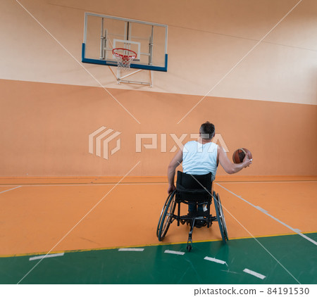a cameraman with professional equipment records a match of the national team in a wheelchair playing a match in the arena 84191530