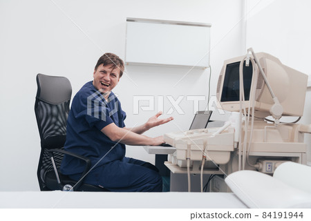 Orthopedist doctor examining X-ray picture at desk in clinic on laptop computer 84191944