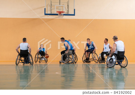disabled war veterans in action while playing basketball on a basketball court with professional sports equipment for the disabled 84192002