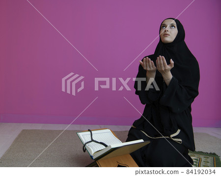 Middle eastern woman praying and reading the holy Quran Middle eastern woman praying and reading the holy Quran 84192034