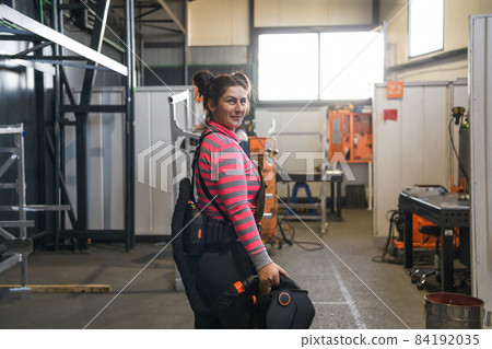a portrait of a women welder holding a helmet and preparing for a working day in the metal industry a portrait of a women welder holding a helmet and preparing for a working day in the metal industry 84192035