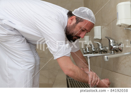 A Muslim takes ablution for prayer. Islamic religious rite A Muslim takes ablution for prayer. Islamic religious rite 84192038