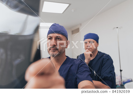 Orthopedist doctor team examining digital X-ray picture in clinic or hospital Orthopedist doctor team examining digital X-ray picture in clinic or hospital 84192039