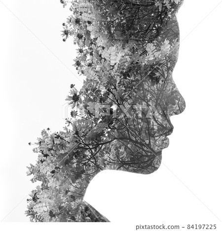A black and white profile portrait of a woman combined with twigs of wildflowers in a double exposure technique 84197225