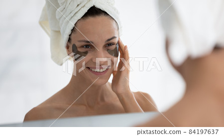 Happy young latin woman applying hydrogel patches. Happy young latin woman applying hydrogel patches. 84197637
