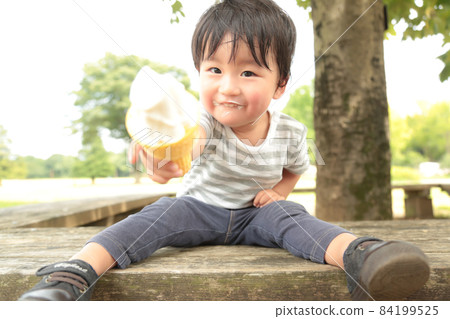 A boy who eats a soft cream 84199525