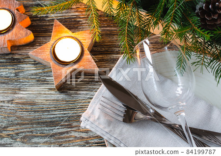 Christmas table setting with candles and fir branches Christmas table setting with candles and fir branches 84199787