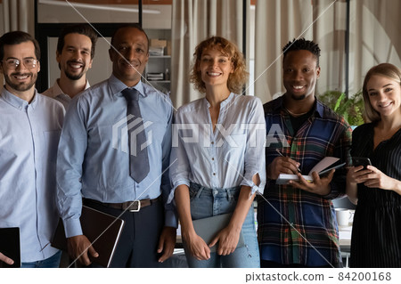 Smiling young mixed race business people posing in modern office. Smiling young mixed race business people posing in modern office. 84200168