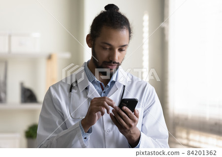 Close up African American man doctor using smartphone in hospital Close up African American man doctor using smartphone in hospital 84201362