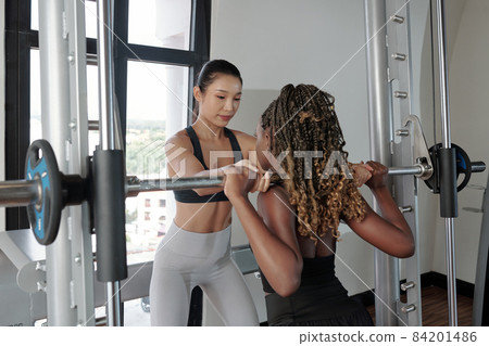 Coach Helping Client with Lifting Weight 84201486