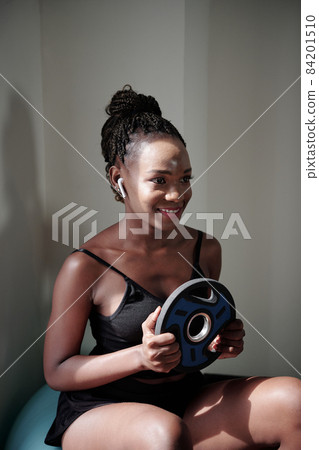 Woman Exercising with Weight Plate Woman Exercising with Weight Plate 84201510