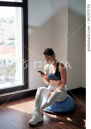 Fitness Trainer Sitting on Hemisphere Fitness Trainer Sitting on Hemisphere 84201516
