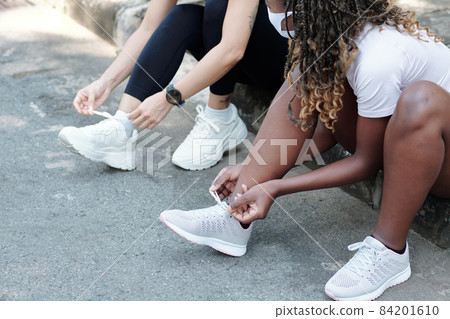 Sportswomen Tying Laces of Sneakers Sportswomen Tying Laces of Sneakers 84201610
